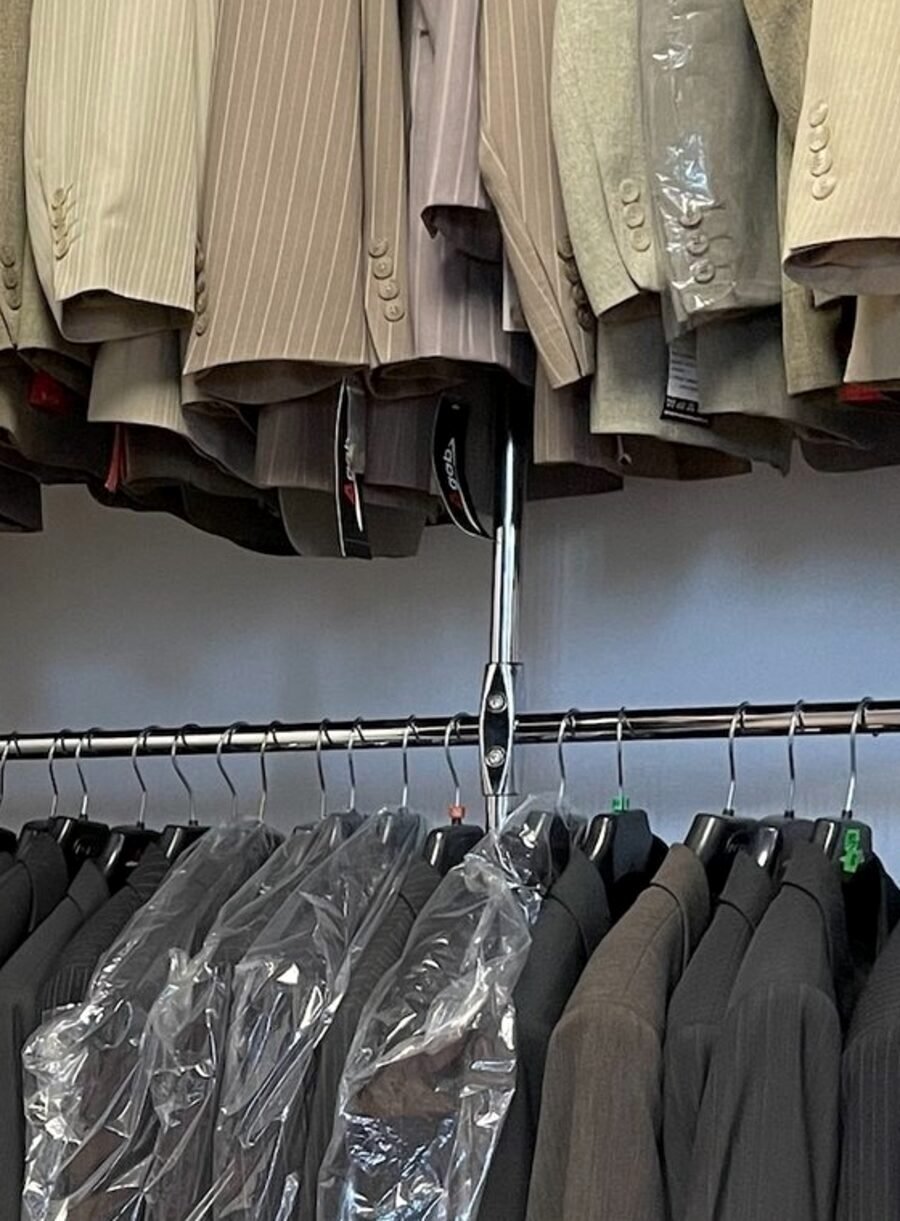 Kostymer och kavajer ur sortimentet, hängande i ateljén